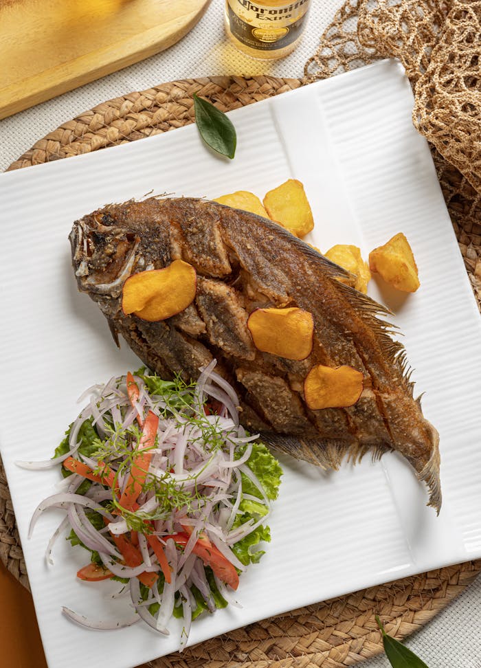 Crispy fried fish served with a fresh onion and tomato salad in Tacna, Peru.